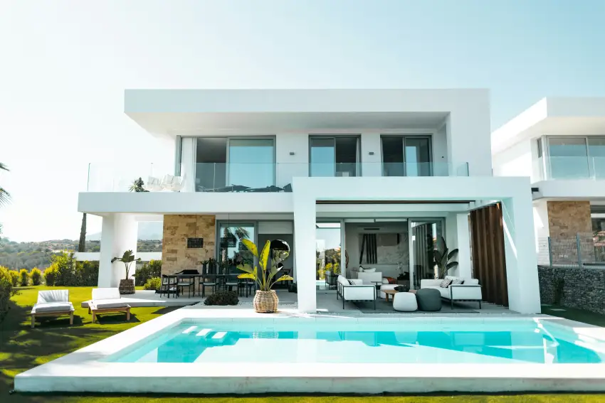 A modern white villa with a covered patio, pergola, and pool photographed in daylight — a design reference image, not an actual Duskline project